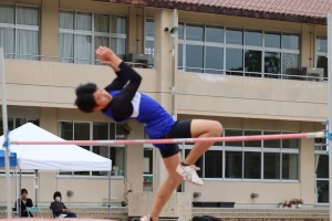 外で生徒が走り高跳びを行っている写真