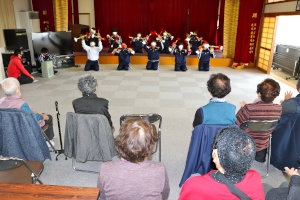 ステージのある大きなホールのような場所で、沢山の老人ホームの入所者の前でダンスを披露している生徒たちの写真