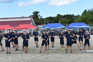 校庭で児童たちが音楽に合わせてダンスをしている写真