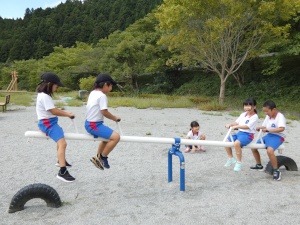 公園でシーソーをして遊ぶ児童たちの写真