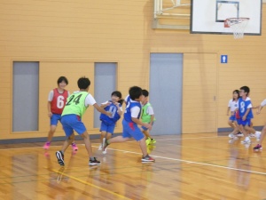 体育館でチーム対抗の試合をする児童たちの写真