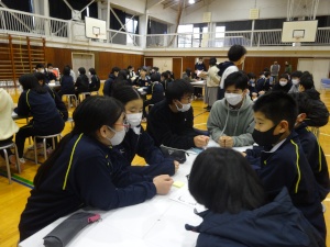 体育館で生徒たちがグループで話し合う写真