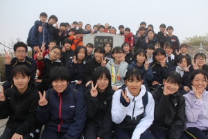 山頂で集合写真を撮る生徒たちの写真