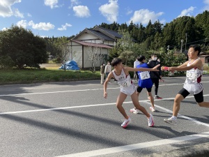 駅伝で生徒がタスキを渡す瞬間の写真