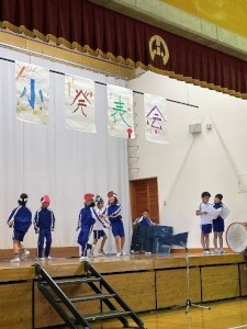 体育館の発表会で劇を披露する児童たちの写真