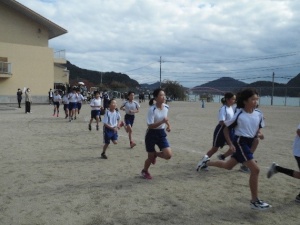 校庭を走る高学年の児童たちのマラソン大会の写真