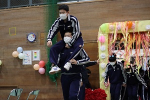 体育館で生徒たちが肩車をして入場する写真