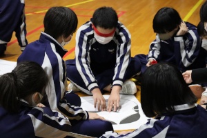 体育館でグループ活動に取り組む生徒たちの写真