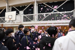 体育館で紙吹雪が舞う中、生徒たちが歓談している写真