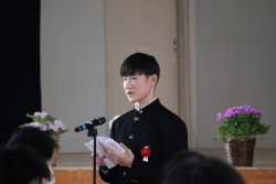 卒業式でマイクの前に立ち、答辞を読む男子生徒の写真