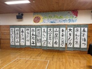 ホールの壁にのびのびとした字で書かれた校内書き初め展の作品が掲示されている写真