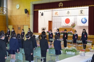 体育館で卒業式に臨む制服姿の児童たちの写真