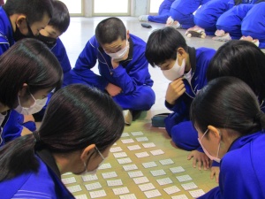 百人一首大会で生徒たちが円になって真剣勝負をしている写真