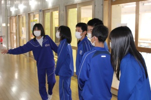 廊下で女子生徒が新入生たちに案内をしている写真