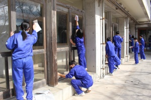 校舎の外で生徒たちが窓を掃除している写真