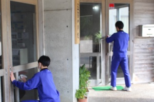 玄関で生徒たちが拭き掃除している写真
