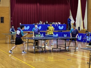 体育館で卓球の試合をする2人の生徒の写真