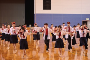 制服姿の生徒たちが体育館で整列して踊っている写真