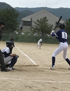 グラウンドで行われている野球の試合で打席に立つ選手の写真