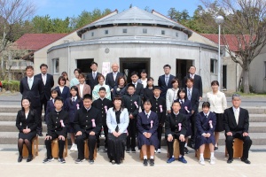 外の階段の前に並ぶ新入生と先生の集合写真