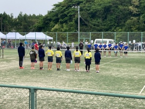 テニスコートで選手たちが横並びで整列している写真