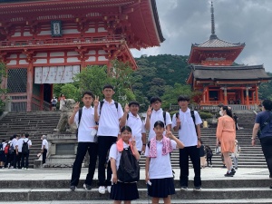 寺院の階段で生徒たちが記念撮影をしている写真