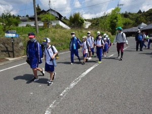 上級生と下級生が2列になって道路を歩いている写真