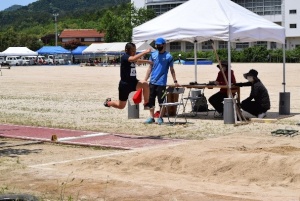 校庭で走り幅跳びをするために助走をつけて飛んでいる瞬間の写真