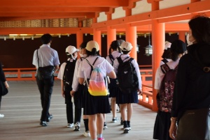 朱色の柱が使用されている建物の中を歩く生徒たちの写真