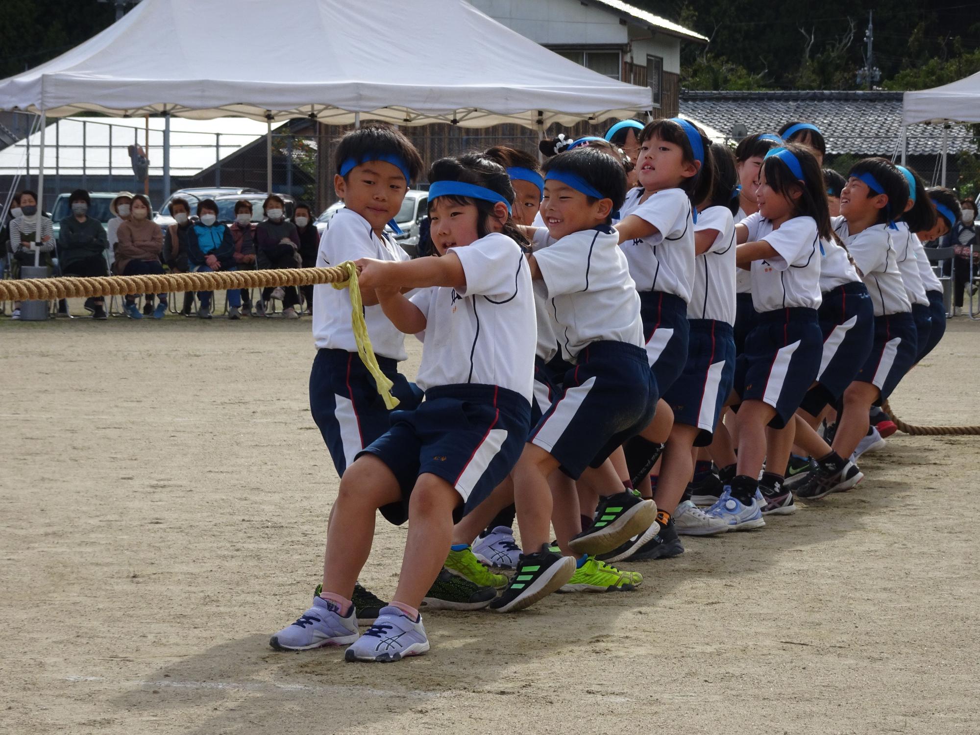 運動会で力を合わせて綱引きをする児童たちの写真