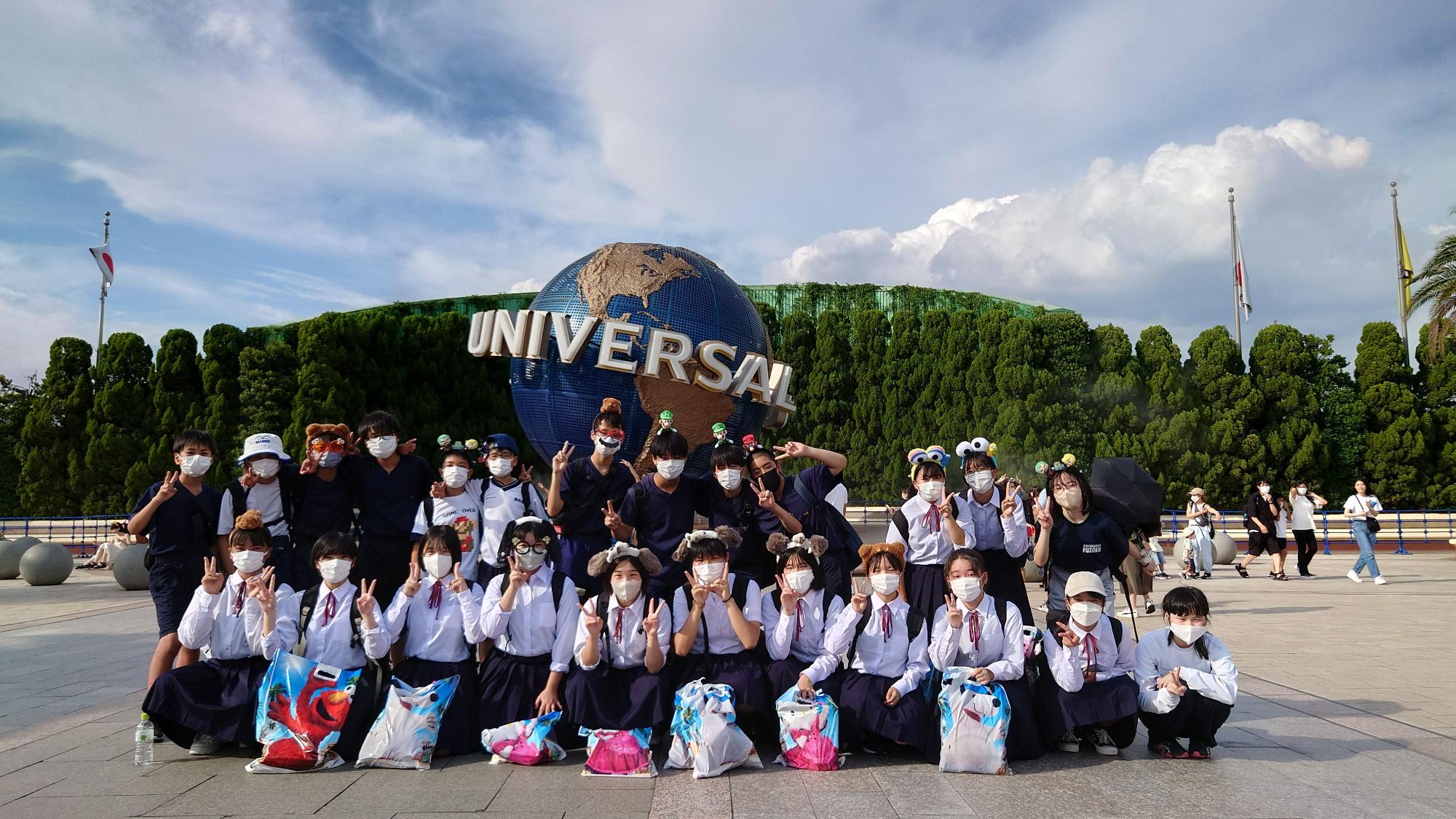 ユニバーサルスタジオジャパンでカチューシャを付けた生徒たちが集合している写真