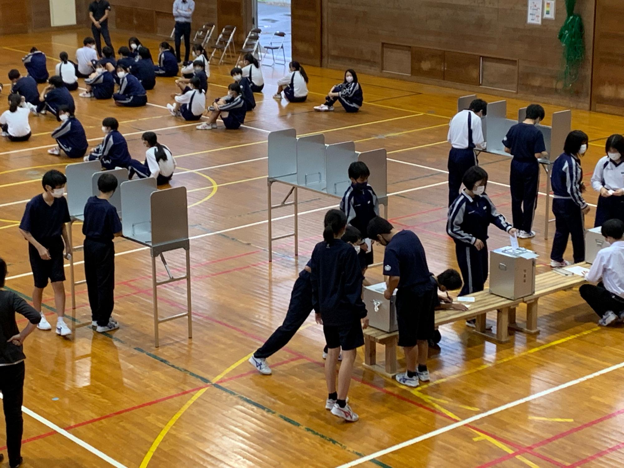 体育館で生徒たちによる投票が行われている写真