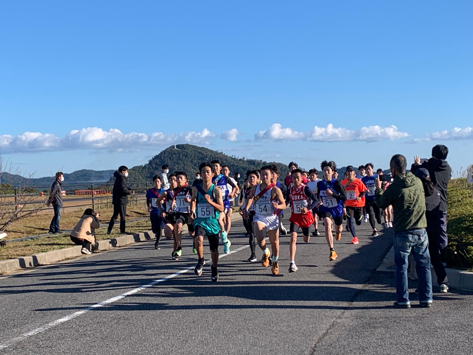 青空の中道路を走る生徒たちの写真