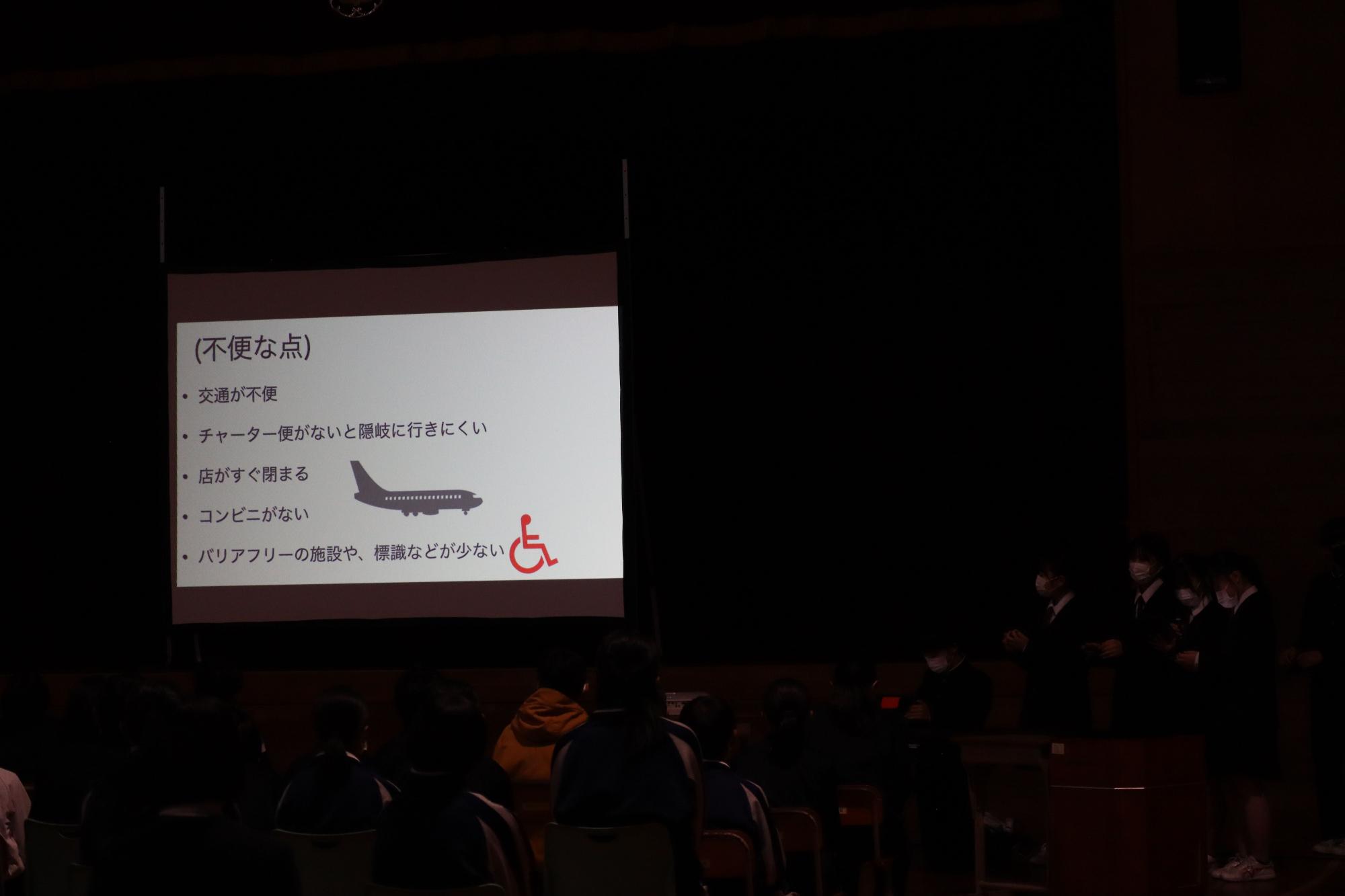 暗い部屋の中にあるスクリーンに不明な点と表示されている写真