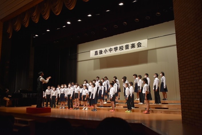 舞台の上で生徒たちが合唱をしている写真