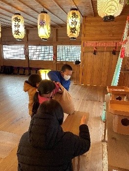 神社の拝殿で収穫した米を奉納している写真