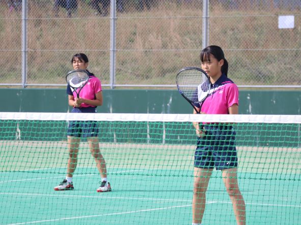 テニスコートで女子生徒たちが試合をしている写真