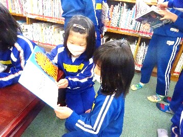 図書室で複数人の児童たちが絵本を読んでいる写真