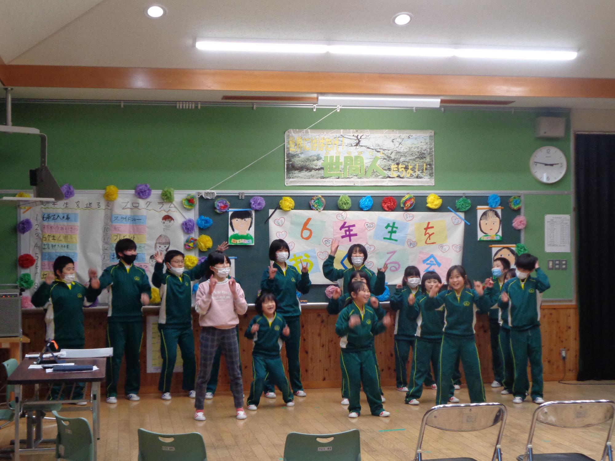教室で児童たちが6年生を送る会で発表している写真