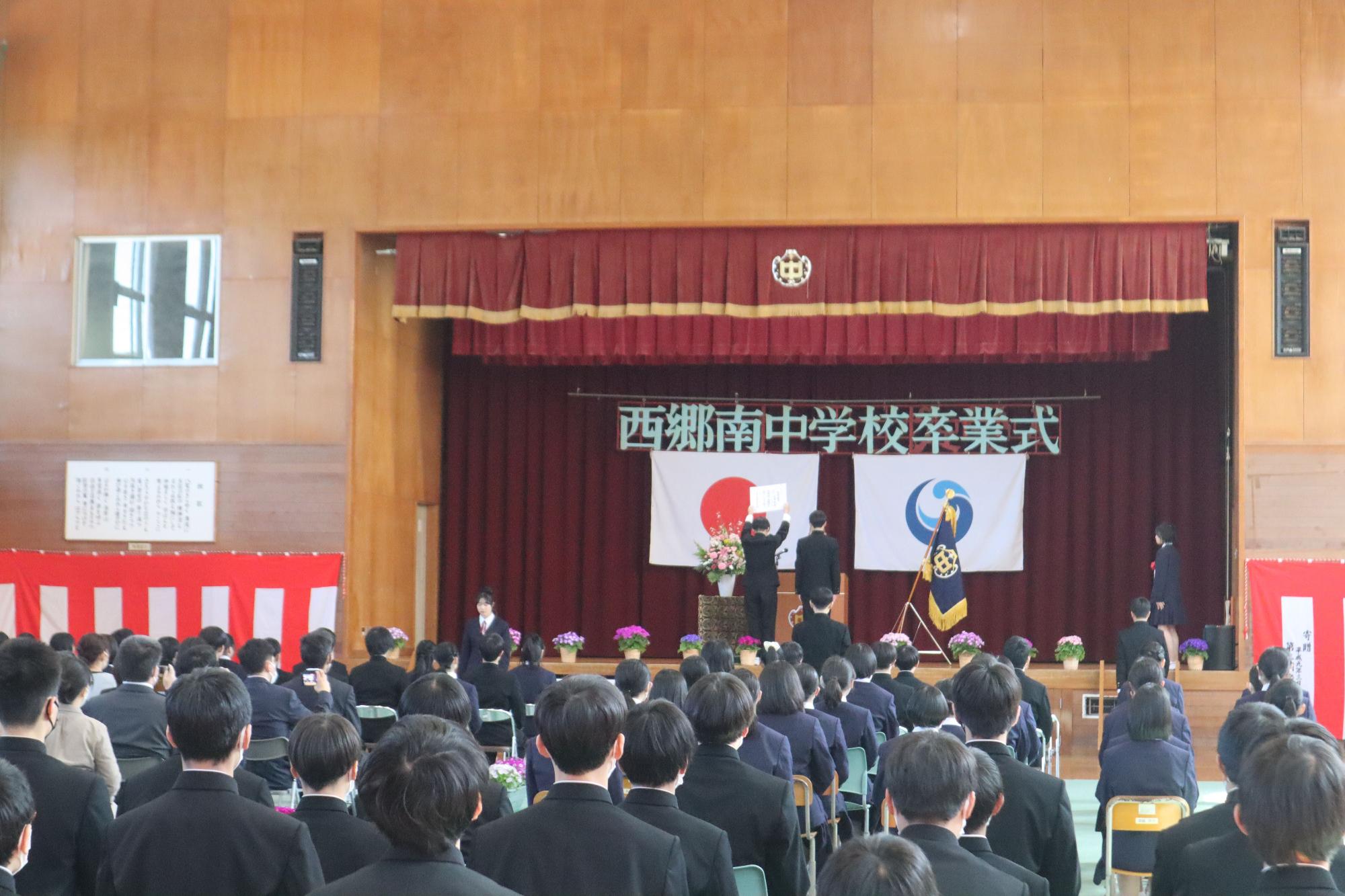 体育館で卒業式の卒業証書授与が行われている写真