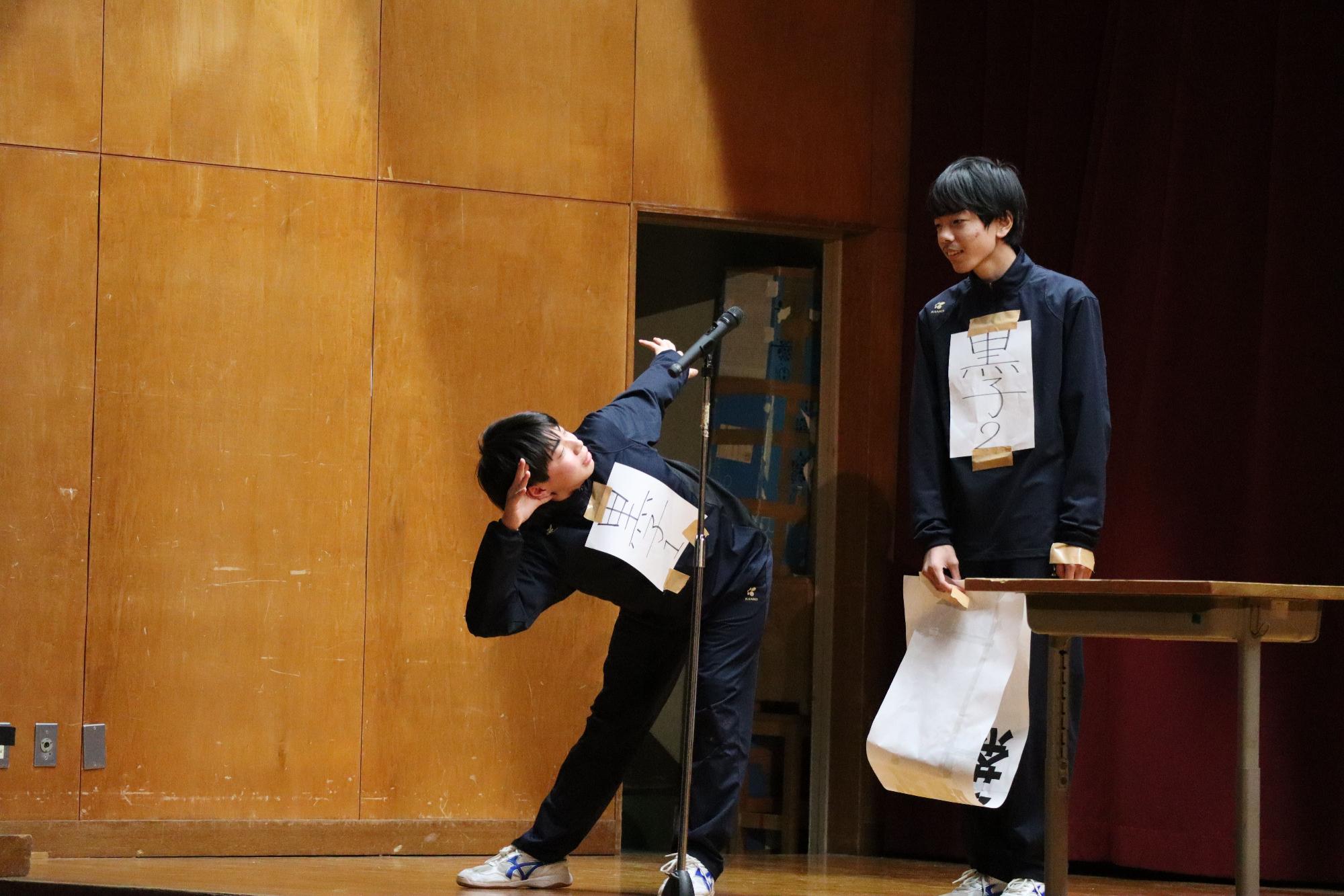 体育館の舞台で男子生徒たちがコントをしている写真