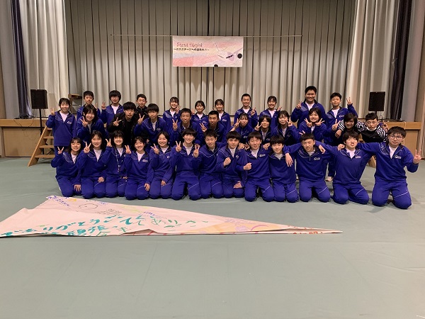 体育館で生徒たちが集合して記念写真を撮っている写真