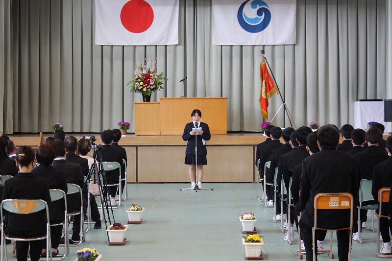 講堂で生徒が卒業式のあいさつをしている写真