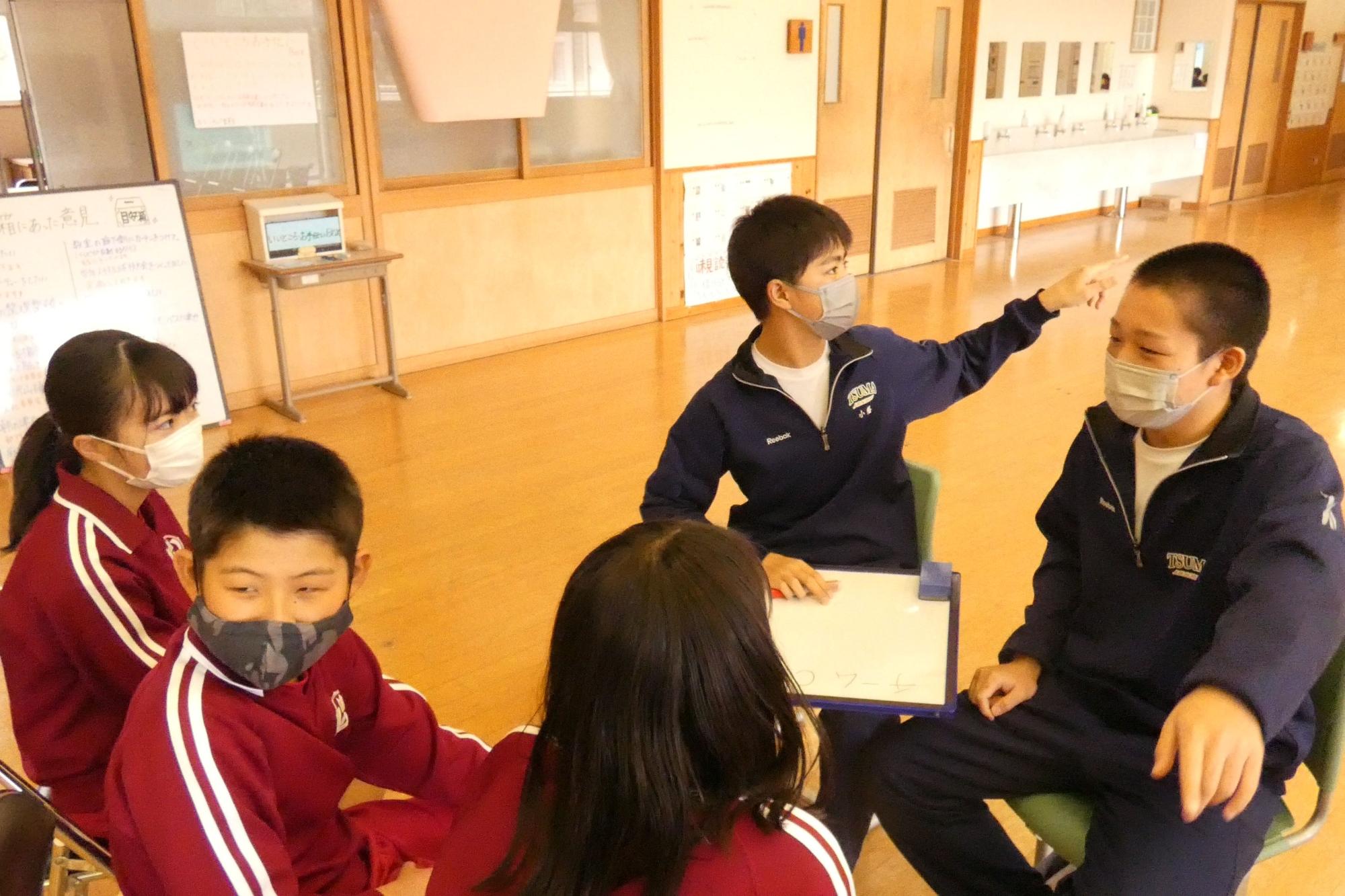 教室で生徒たちがグループで話し合い活動をしている写真