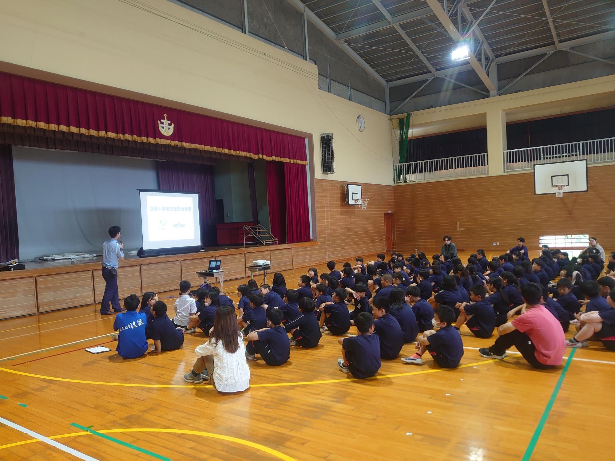 体育館で講話を聞く生徒たちの写真