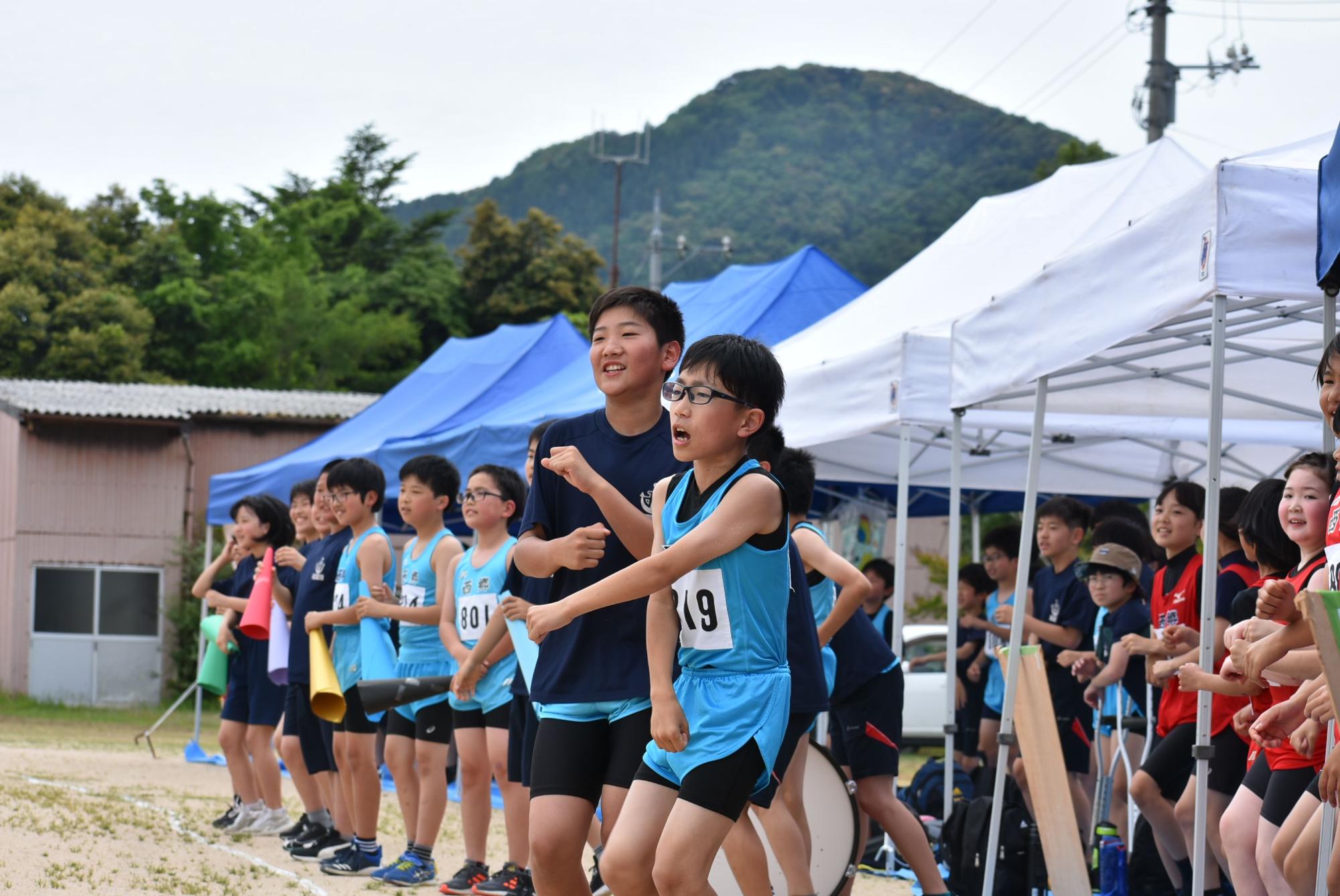 陸上大会で応援する児童の写真