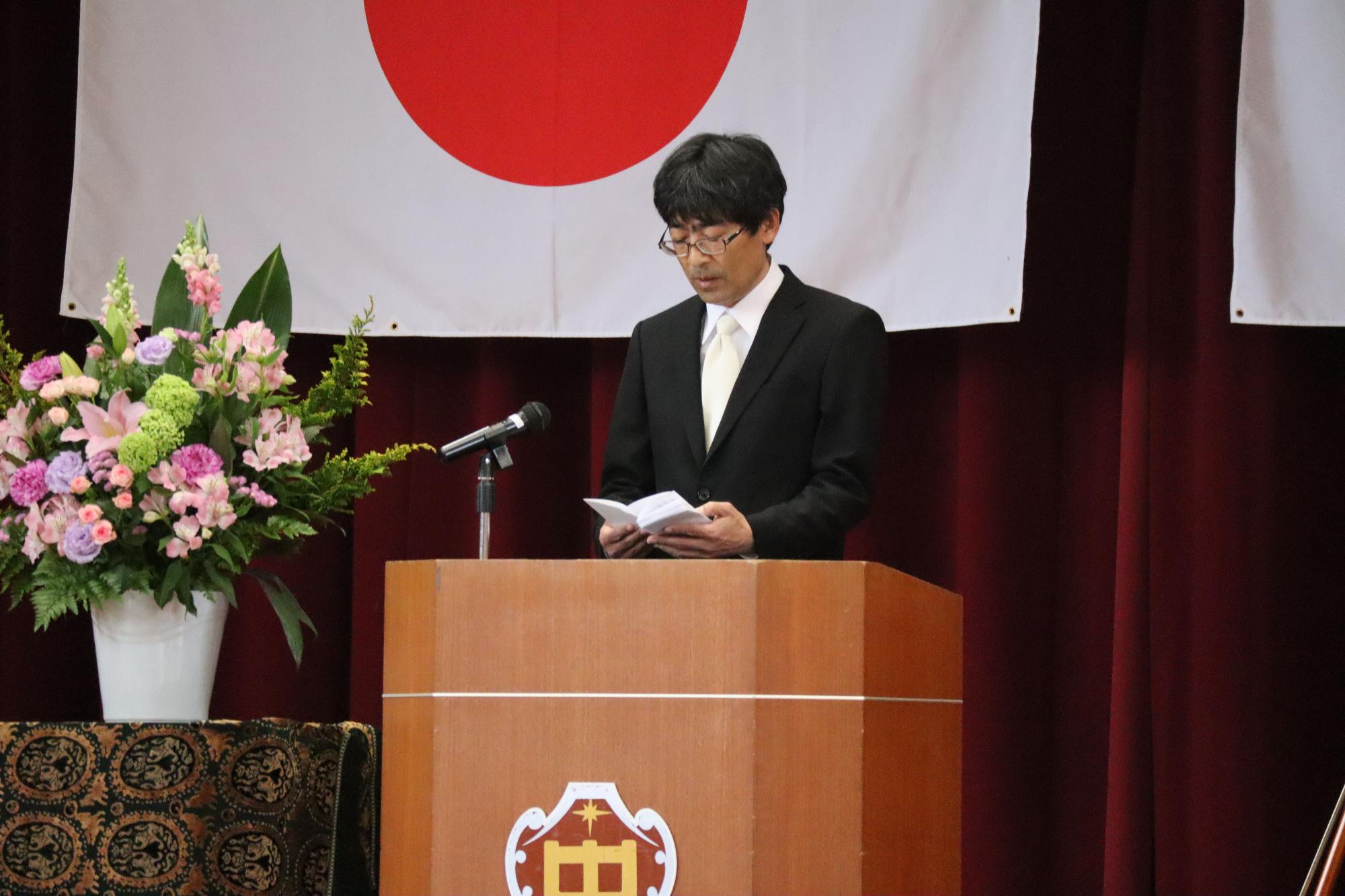 壇上で男性教員が入学式の式辞を述べている写真