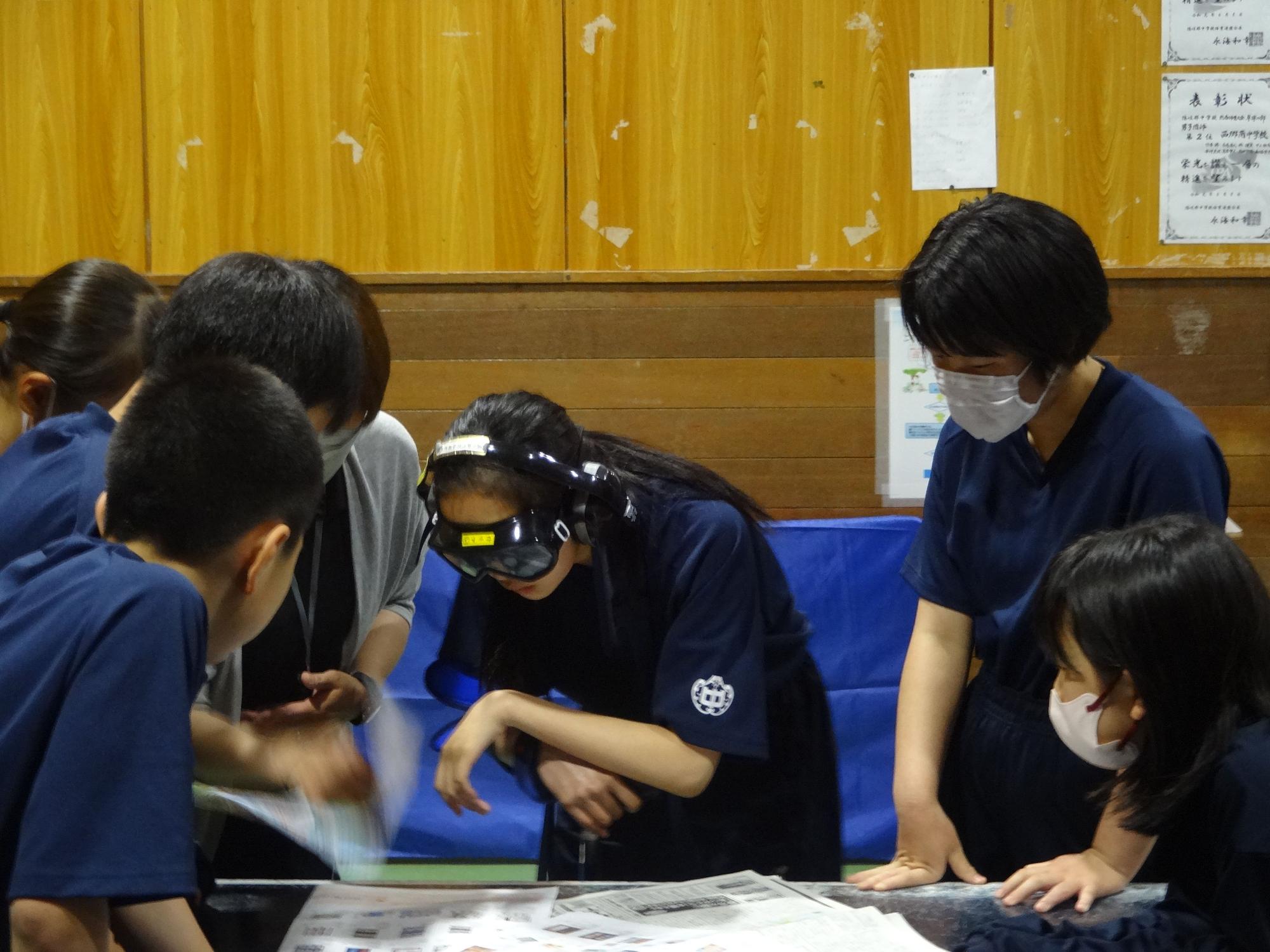 教室で生徒がゴーグルをつけて実験に取り組んでいる写真