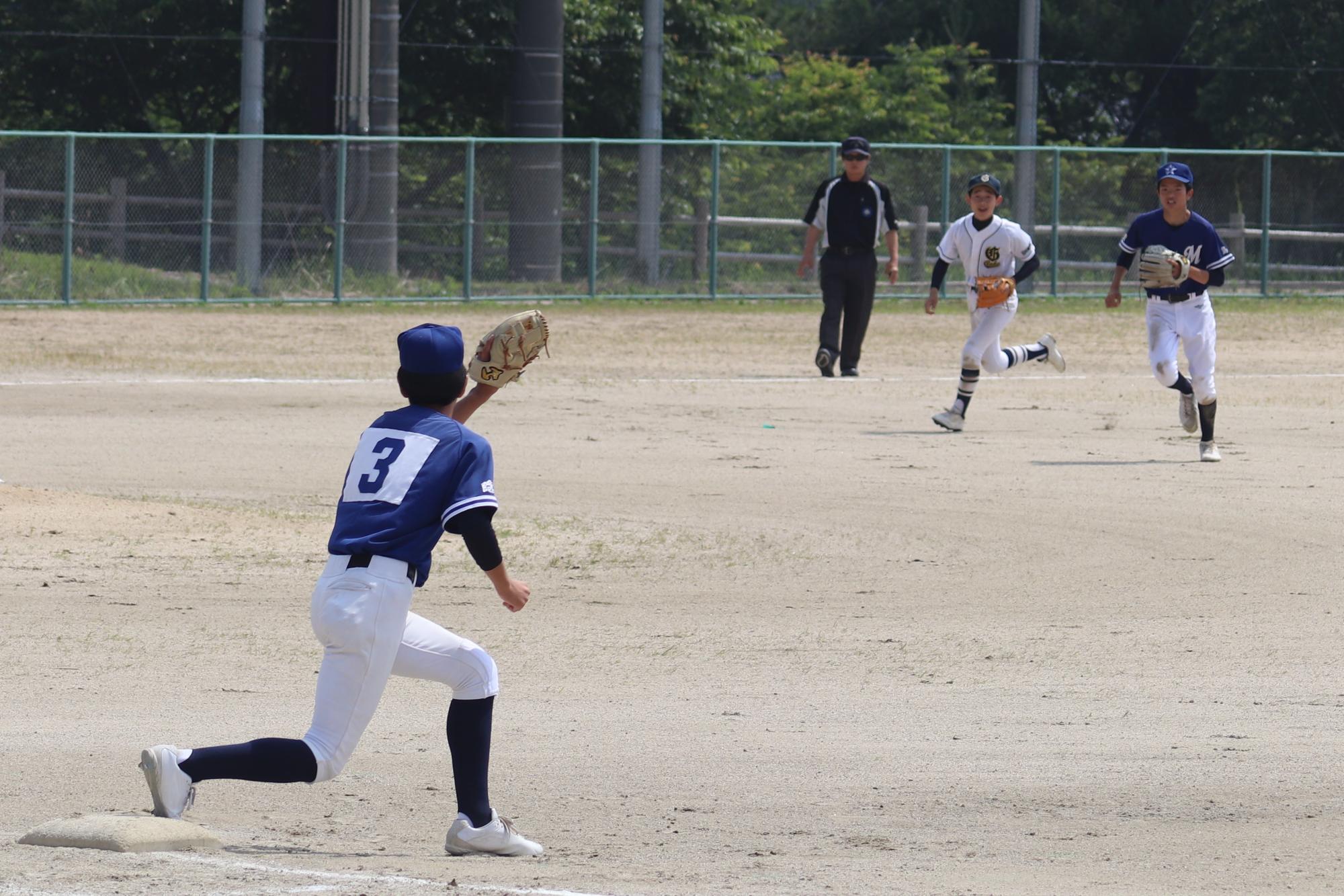 野球の試合で一塁手が送球をキャッチしようとしている写真