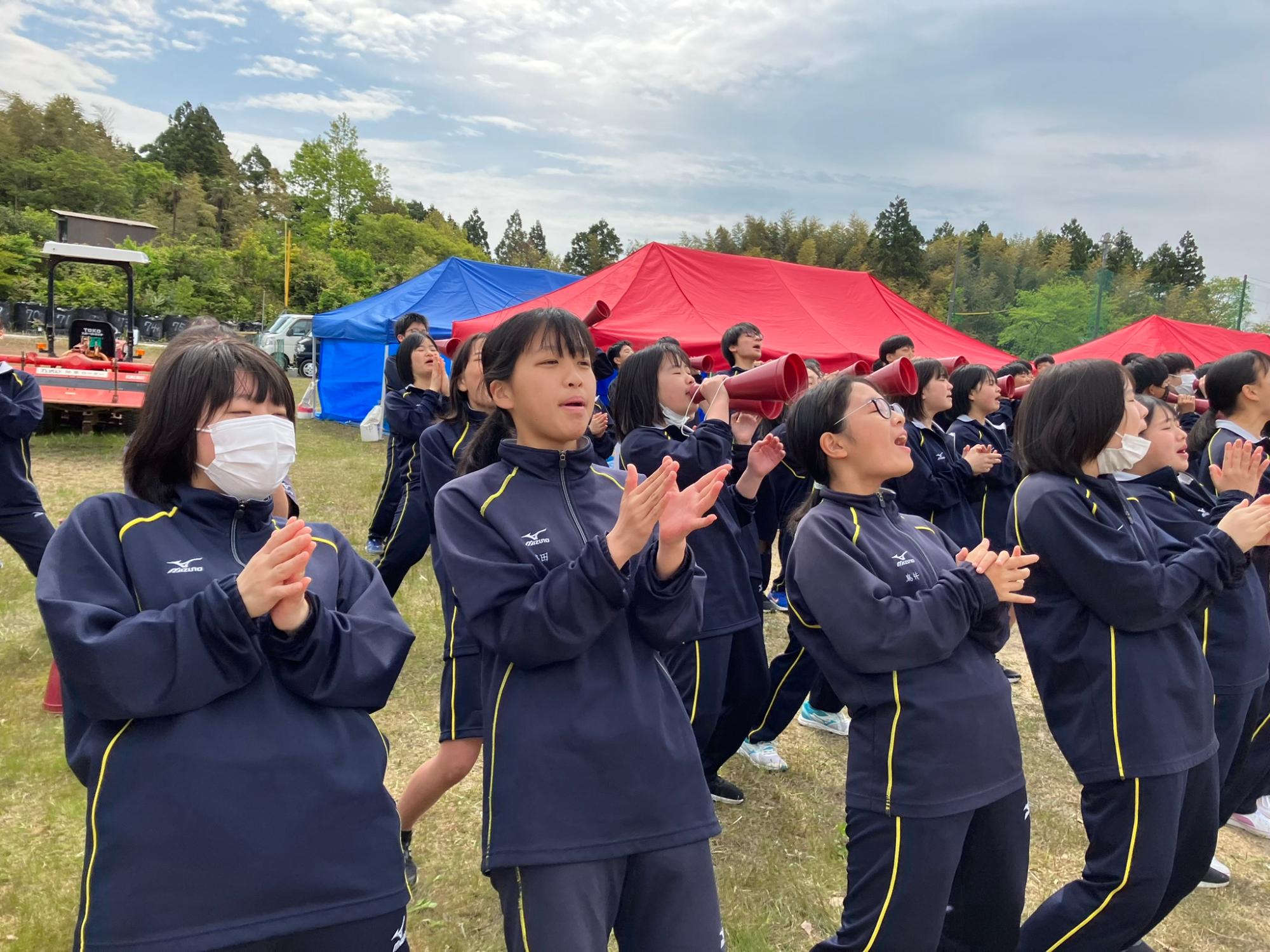 運動会で女子生徒たちが声援を送る写真